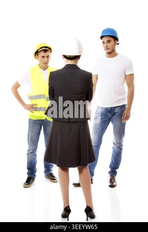 Female engineer talking with two builders Stock Photo