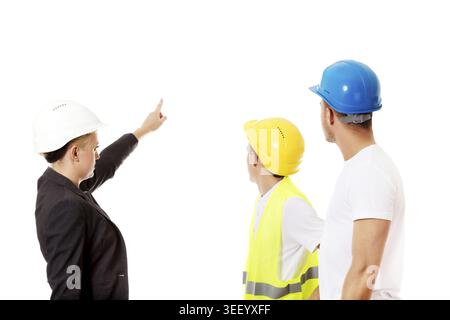 Female engineer talking with two builders and pointing for something Stock Photo