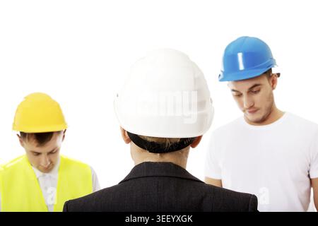 Female engineer talking with two builders Stock Photo