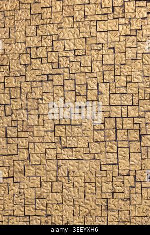 Top view of beige stone pavement with small square tiles forming a geometric pattern. Natural textured surface ideal for backgrounds, design, architec Stock Photo