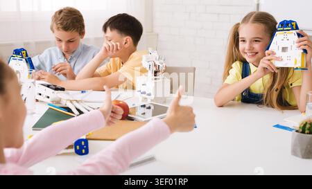 Children Engaged in a Fun Robotics Activity in a Bright Classroom Setting Stock Photo