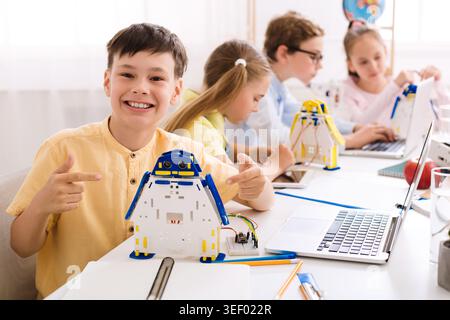 Children Engaged in Robotics Workshop Creating Penguin Models With Technology at School Stock Photo