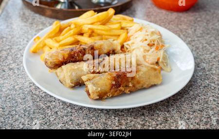 Fried spring rolls. Crispy springrolls, roasted egg rolls with French fries and Vietnamese sauces, Asian rebung, oriental loempia, popiah or nem, lump Stock Photo