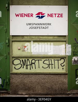 Vienna, Austria - August 4, 2020: A Wiener Netze Umspannwerk Josefstadt substation sign hangs above green metal door with black Smartshit spray painte Stock Photo