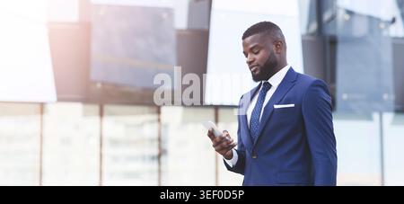 Businessman Using Smartphone With Business Application Walking In City, Panorama Stock Photo