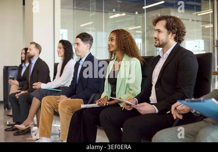 Coworkers listening at corporate training seminar, taking notes during team meeting Stock Photo
