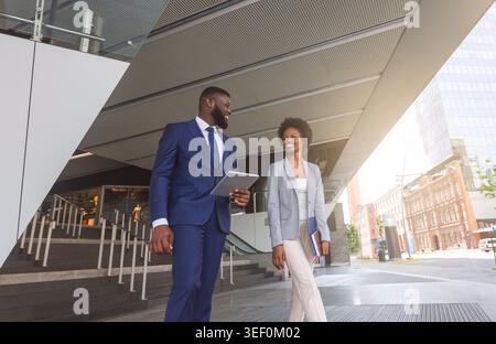 Two african american colleagues discussing new project outdoors Stock Photo