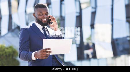 Entrepreneur Talking On Cellphone Holding Documents Standing In City, Panorama Stock Photo