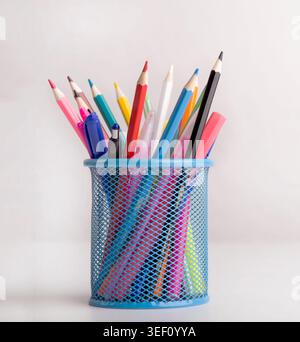Close up of colored pencils in blue transparent stand on white Stock Photo