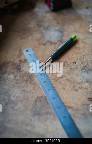 Steel ruler and clutch pencil on wooden workbench in carpentry workshop Stock Photo