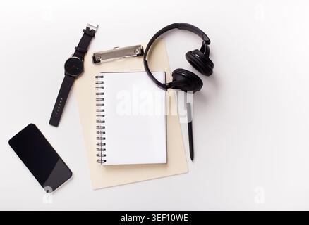 Cellphone, notebook and headphones on white background Stock Photo