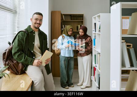 Portrait of Male Student Supporting Migrant Education in Library Stock Photo