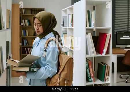 Adult Muslim Woman Studying in Library for Migrant Education Stock Photo