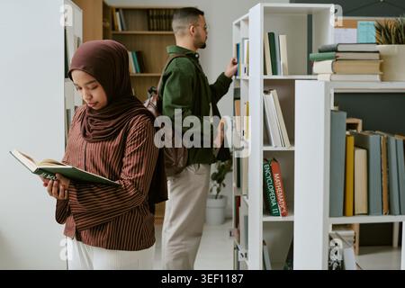 Muslim Student Studying in Library for Migrant Education Support Stock Photo