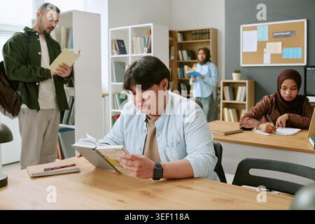 Multiethnic Adult Students Reading in Classroom for Integration Stock Photo