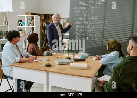 Migrant Students Learning Business English with Teacher in Classroom Stock Photo