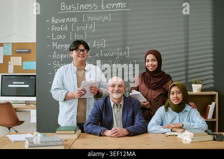 Portrait of Senior Teacher and Migrant Students in Business English Stock Photo