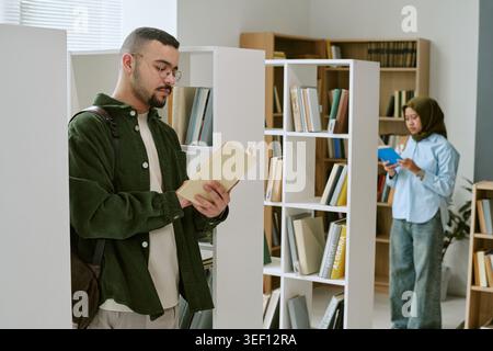 Migrant Man Studying in Library for Education Integration Campaign Stock Photo