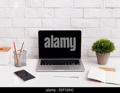 Laptop with black screen on office table Stock Photo