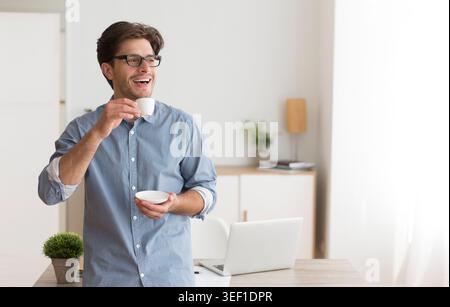 Enjoying a Warm Beverage at Home While Working on a Laptop During the Morning Hours Stock Photo