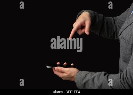 Person Interacting With Smartphone While Pointing at Screen in Dim Lighting Setting Stock Photo