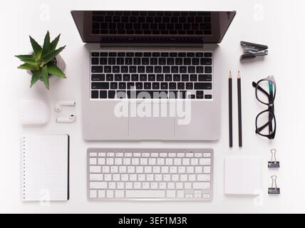 Top view of white office desk with laptop and other supplies Stock Photo