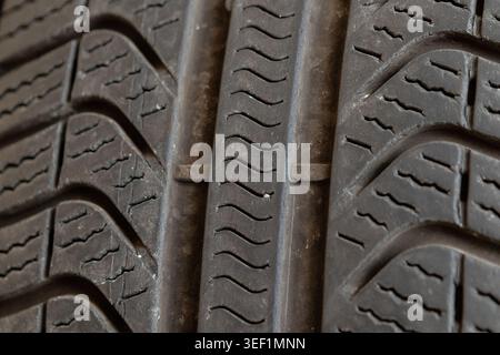 Car tire featuring worn rubber and detailed tread pattern, needing maintenance Stock Photo