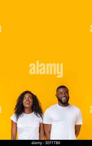 Amazed african american man and woman looking upwards Stock Photo