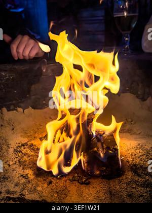 Close up of bright orange and yellow flames burning in an outdoor fire pit Stock Photo