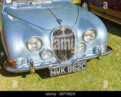 Front view of a light blue classic Jaguar S-type .saloon parked on grass at a car show in the UK showing the distinctive radiator grille and headlights Stock Photo