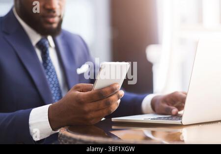 Business Professional Works at Desk With Laptop and Phone in Office Setting Stock Photo