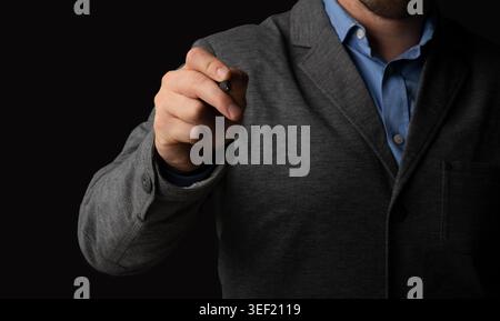 Business Professional Holding Pen With Focused Expression Against Dark Background Stock Photo