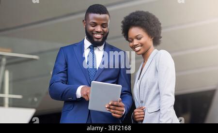 Young african american business partners using digital tablet outdoors Stock Photo