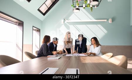 Businesspeople reviewing documents, discussing data, planning strategy Stock Photo