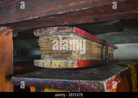 Ancient Tibetan Buddhist manuscript with aged paper pages, traditional religious text preserved in monastery library. Historical document and culture Stock Photo