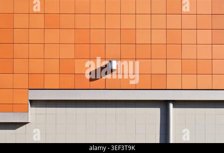 Modern clay ventilated facade with the lower side covered with gray porcelain tiles. Background and texture. Stock Photo