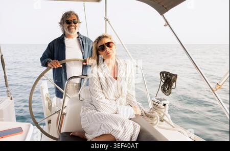 Happy mature couple sailing on a yacht, enjoying luxury summer vacation Stock Photo