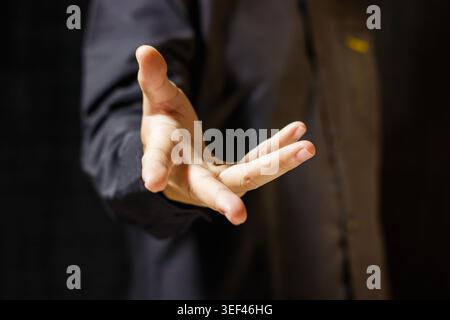 Man's hand reaching out in a gesture of offering or asking. Body Language. Business Concept. Offering and Asking Hand Gesture. High quality photo Stock Photo