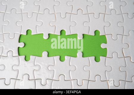 Jigsaw puzzle on green background, business teamwork, problem solving concept. Stock Photo