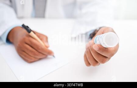 Person, doctor and hands writing with pills for medical prescription, diagnosis or symptoms. Healthcare worker, taking notes or container with tablets Stock Photo