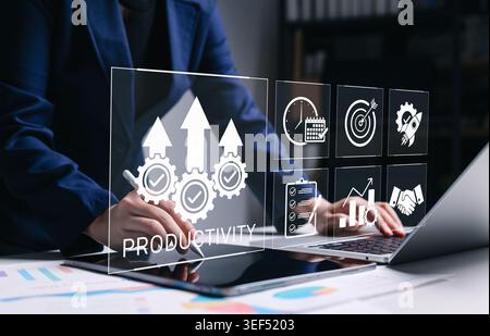 Business productivity management concept. Businesswoman using laptop to analyze growth icons. efficiency optimization, KPI, corporate success strategy Stock Photo