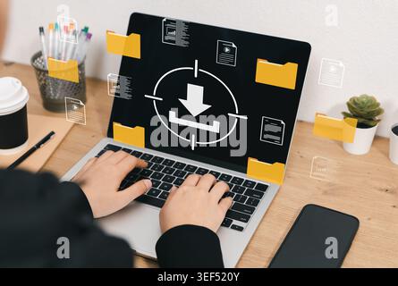 Digital file download and document storage management concept. User using laptop with virtual download icon, folders, media files, reports, data Stock Photo