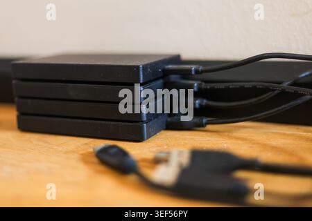 Stack of portable external hard drives representing digital storage backup and data security technology Stock Photo