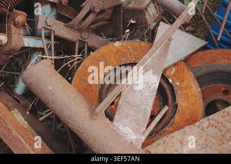 Detailed textured close up of a pile of rusty metal objects including a brake rotor and pipes representing industrial decay and recycling themes Stock Photo