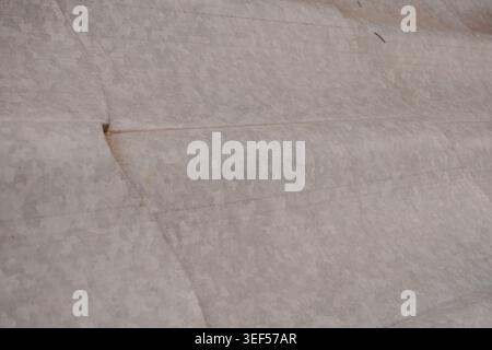 Abstract macro view of a rough textured beige fabric showing subtle shadows and highlights on its woven surface a neutral material for creative design Stock Photo