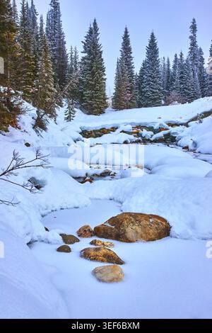 Snow Covered River and Rocks in Winter Forest Landscape Stock Photo