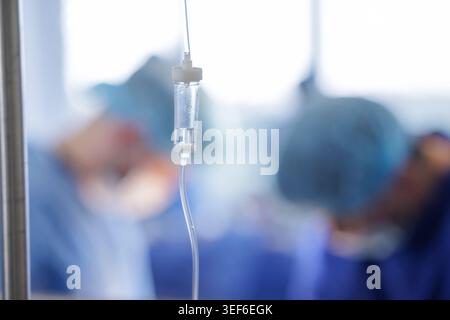 An intravenous drip is prominently featured in a modern surgical setting, highlighting the critical support provided to patients during medical proced Stock Photo