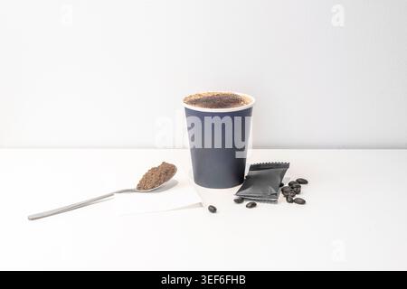 A matte black cardboard cup with a matching lid and a minimalist coffee leaf design, captured inside a car, reflecting the city lights through the fog Stock Photo