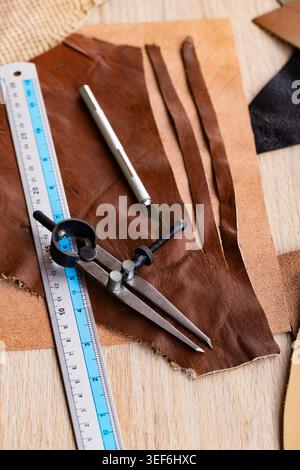 Leather Craft Workshop Flat Lay with Tools Ruler Pencil and Various Leather Pieces on Wooden Table Stock Photo
