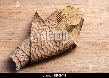 Beige and Gold Snake Skin Leather Texture on Wooden Surface, Luxury Material Close-Up Stock Photo